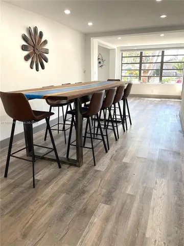 a view of a a dining room with furniture window and wooden floor
