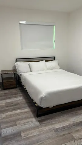 a large bed sitting in a bedroom next to a window