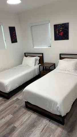 a bedroom with two beds and a desk