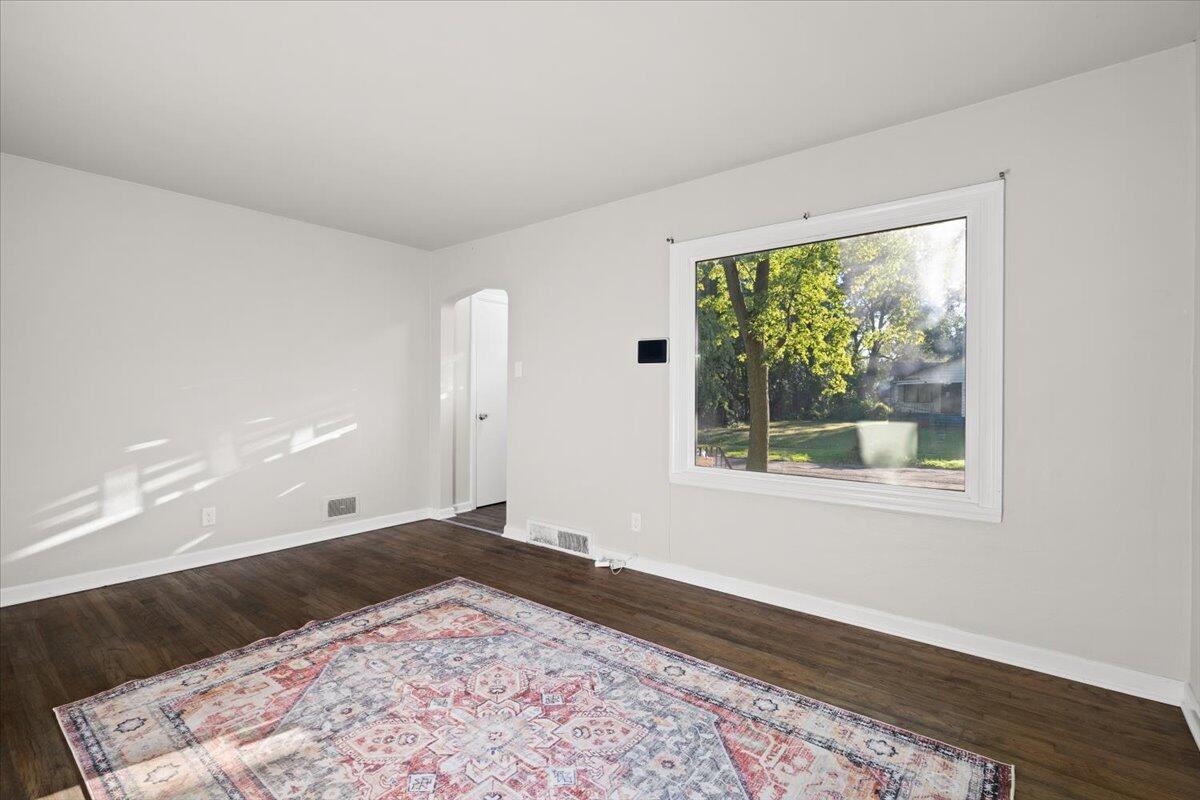 3642 Buchanan Street Gary, IN 46408 - Photo 7 of 25 a view of an empty room with wooden floor and a window