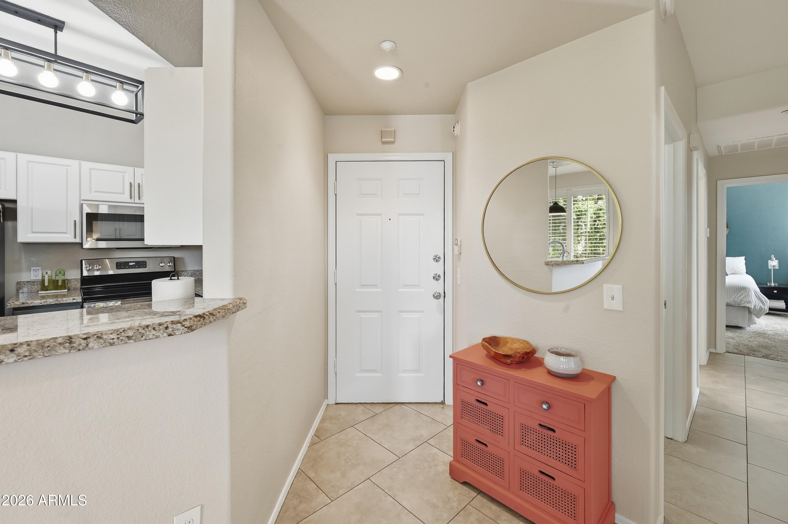 5303 North 7th Street, Unit 220 Phoenix, AZ 85014 - Photo 7 of 33 a living room with furniture a mirror and a clock on wall