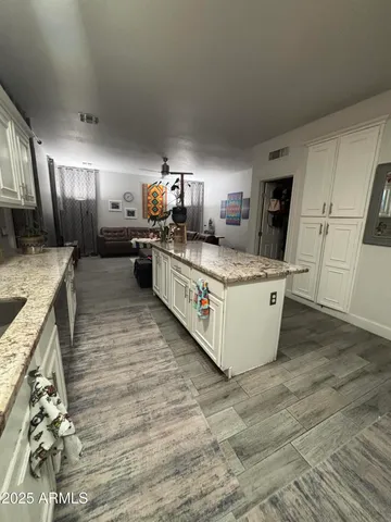 a view of a hallway with wooden floor and cabinets