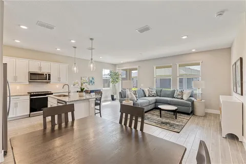 a living room with furniture dining table and a large window