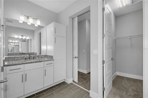 a bathroom with a granite countertop sink a mirror and a shower