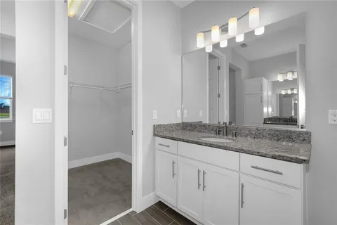 a bathroom with a granite countertop sink a mirror and a vanity