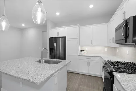 a kitchen with stainless steel appliances granite countertop a sink refrigerator and microwave