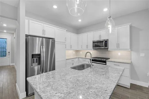 a kitchen with stainless steel appliances granite countertop a refrigerator stove microwave and sink