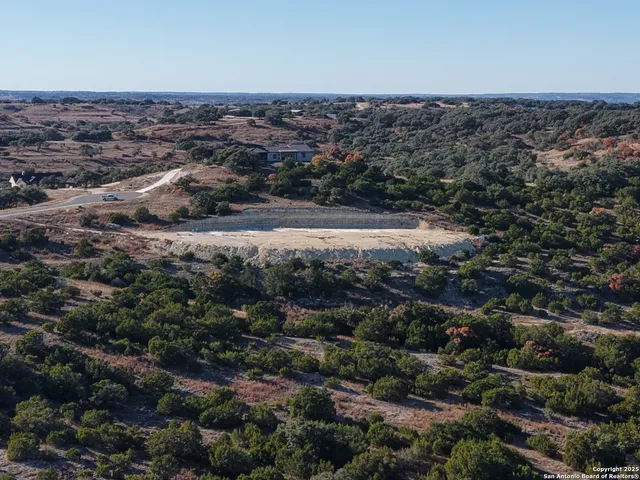 an aerial view of house with yard and mountain in back