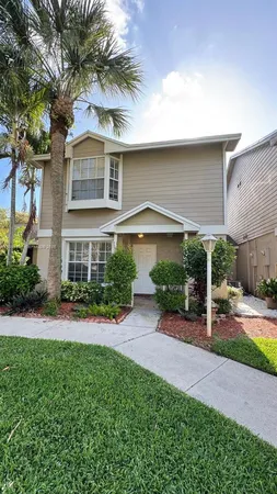 a front view of a house with a yard and potted plants