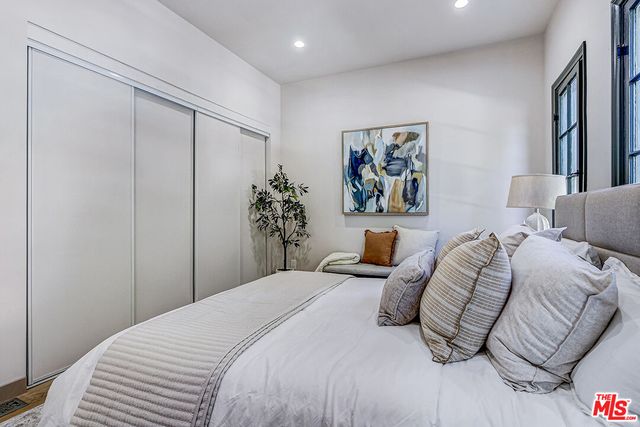 a bedroom with a large bed and a chandelier