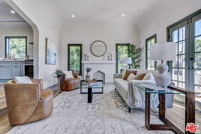 a living room with furniture a table and a large window