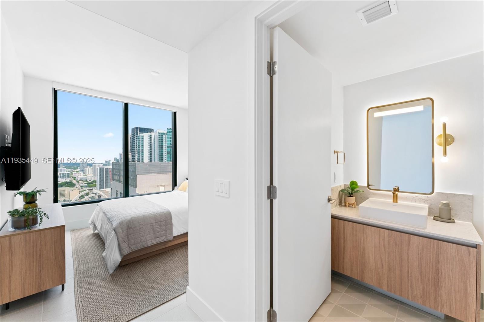 159 Northeast 6th Street, Unit 4415 Miami, FL 33132 - Photo 18 of 47 a en suite bathroom with a double vanity sink and a mirror