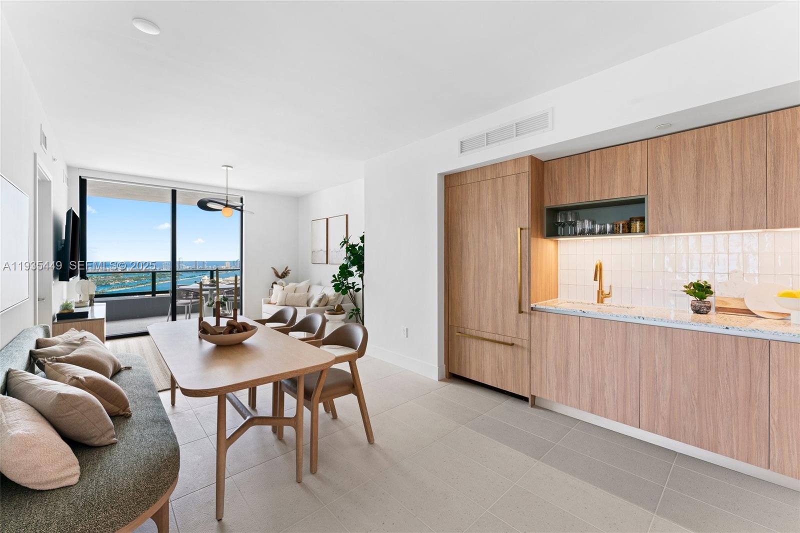 159 Northeast 6th Street, Unit 4415 Miami, FL 33132 - Photo 28 of 47 a kitchen with stainless steel appliances a table and chairs in it