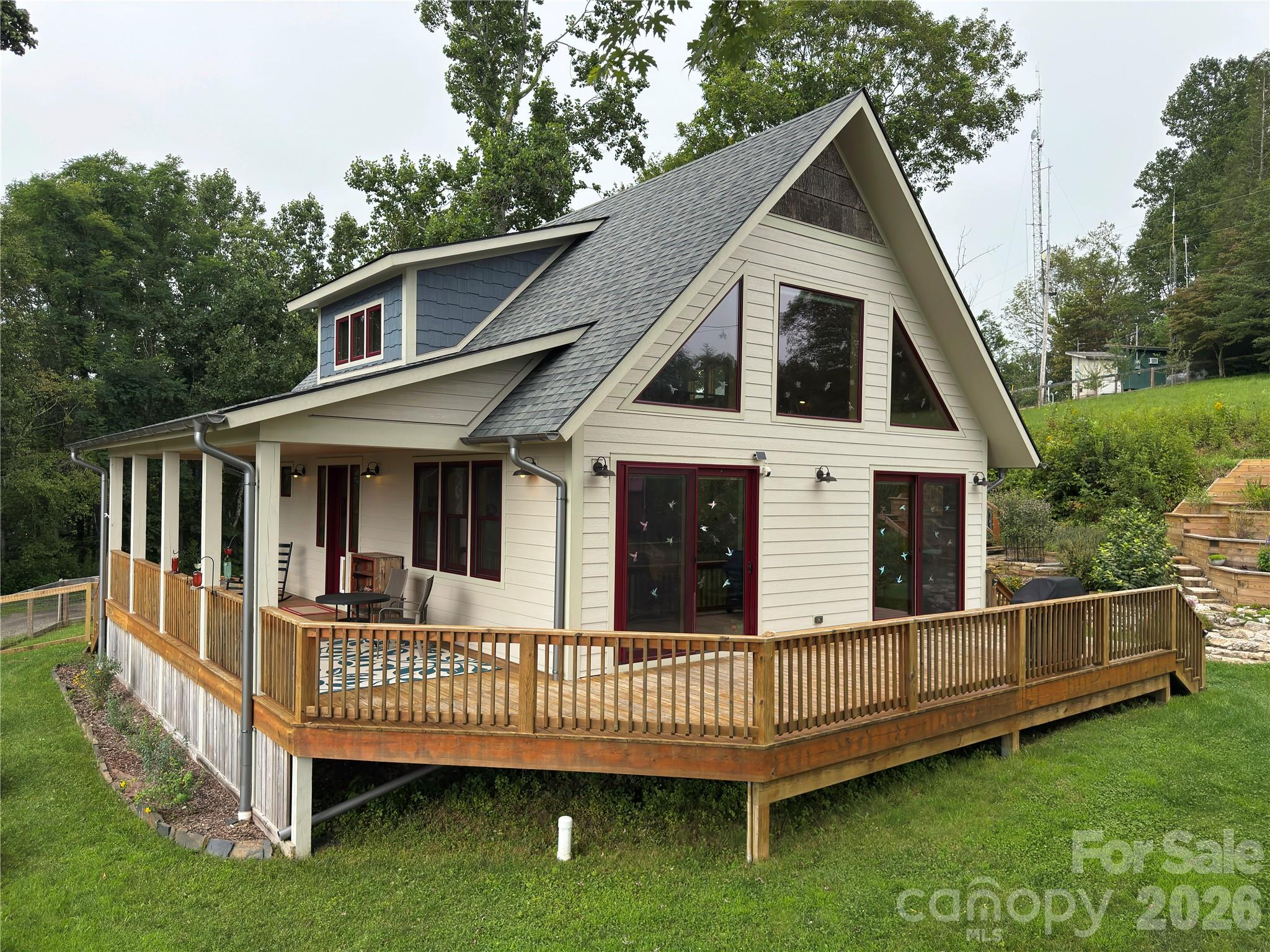 a view of a house with a yard and deck wooden fence