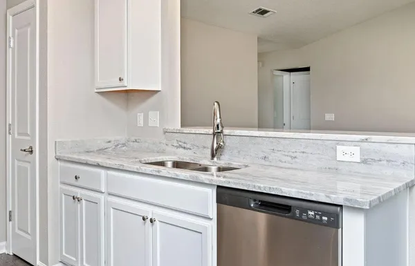 a kitchen with granite countertop a sink and cabinets