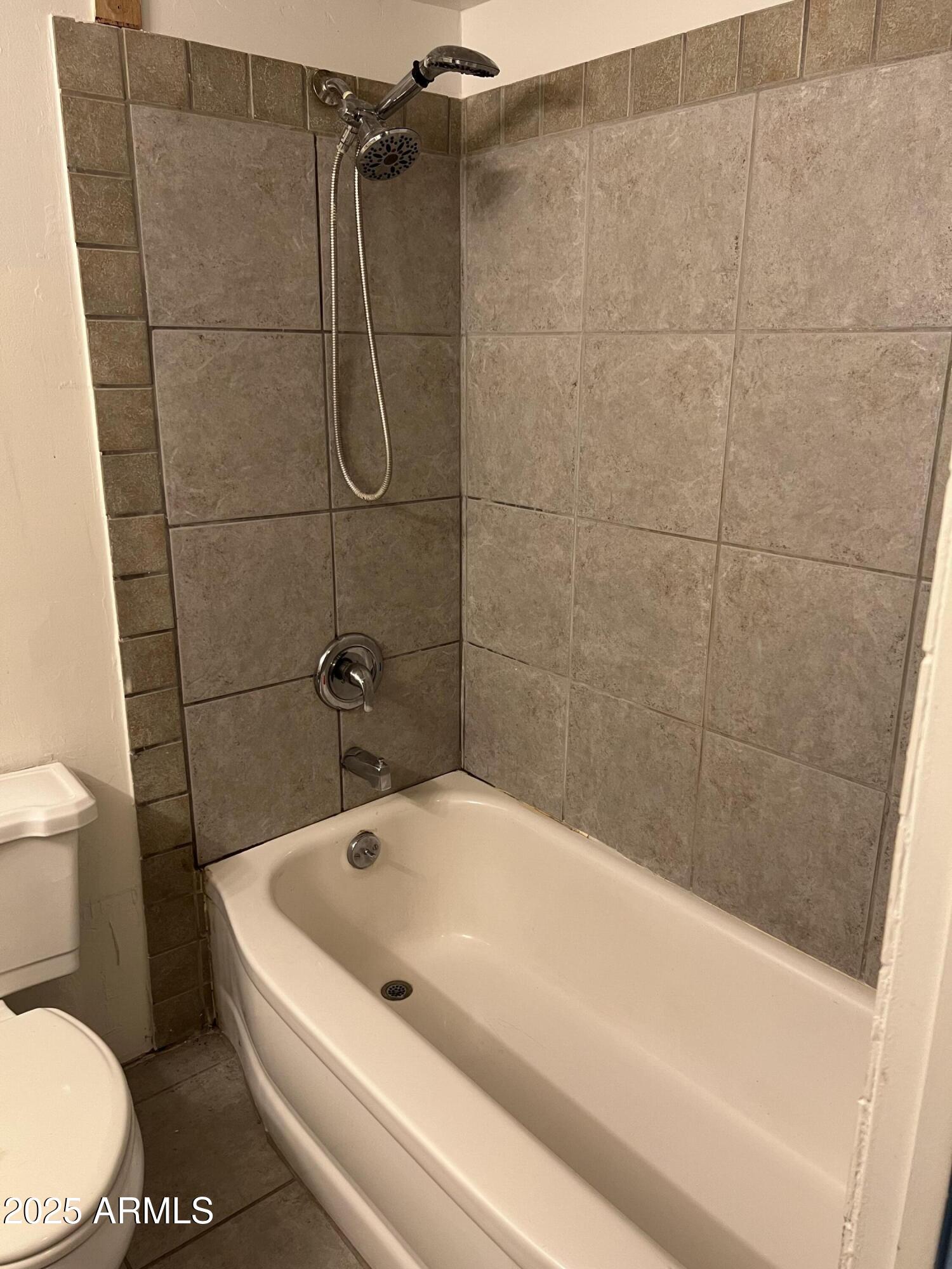 2530 West Berridge Lane, Unit E102 Phoenix, AZ 85017 - Photo 15 of 15 a white bath tub sitting next to a toilet