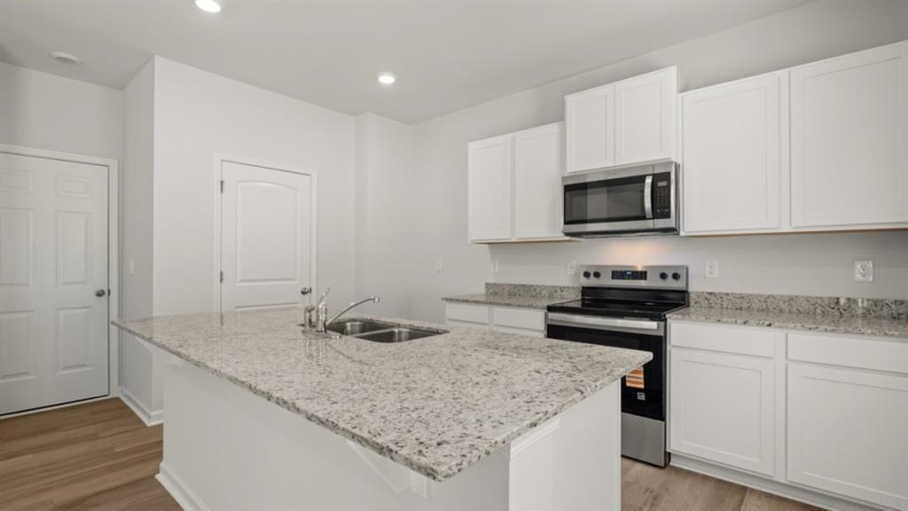 519 Oak View Lane Dallas, GA 30157 - Photo 8 of 35 a kitchen with granite countertop a sink dishwasher stove and microwave with wooden floor