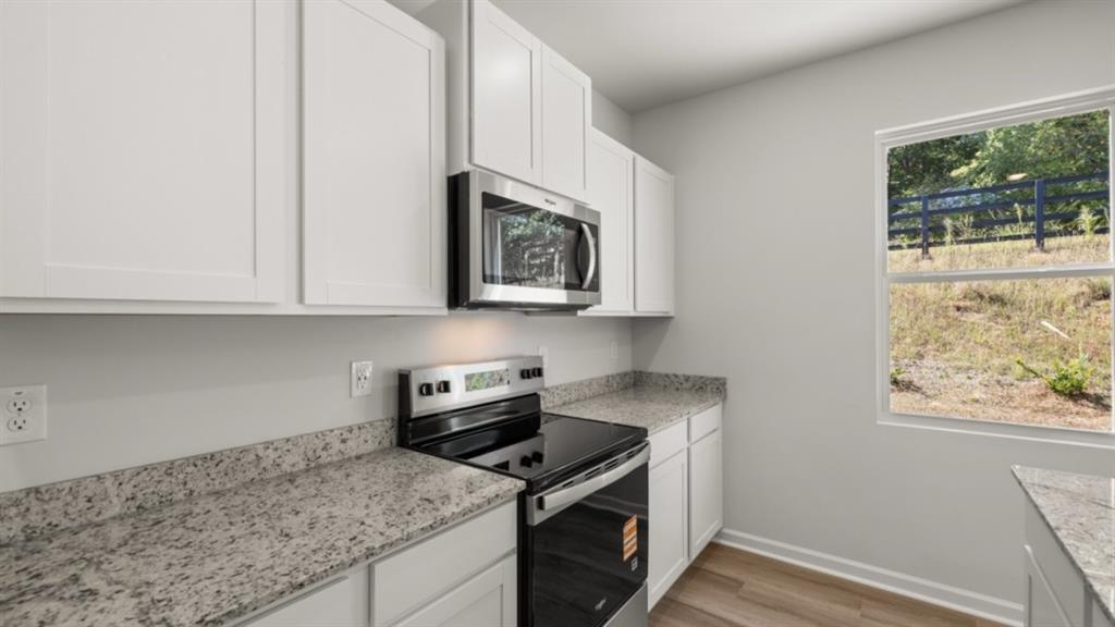 519 Oak View Lane Dallas, GA 30157 - Photo 10 of 35 a kitchen with stainless steel appliances granite countertop a stove a sink and a microwave