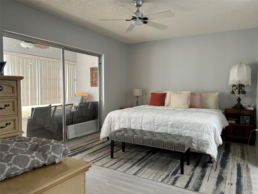 6770 Royal Palm Boulevard, Unit 301L Margate, FL 33063 - Photo 14 of 32 a bedroom with a bed and wooden floor