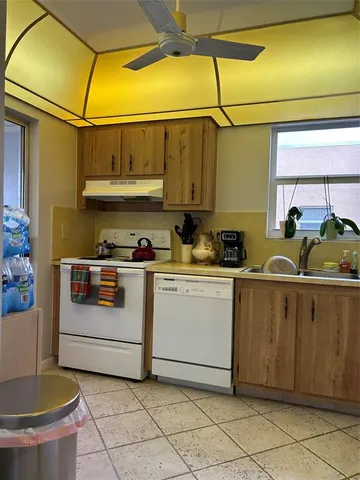 a kitchen with a sink a stove and cabinets
