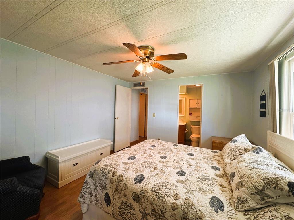 151 Hibiscus Way Leesburg, FL 34748 - Photo 20 of 30 a bedroom with a bed and a chandelier
