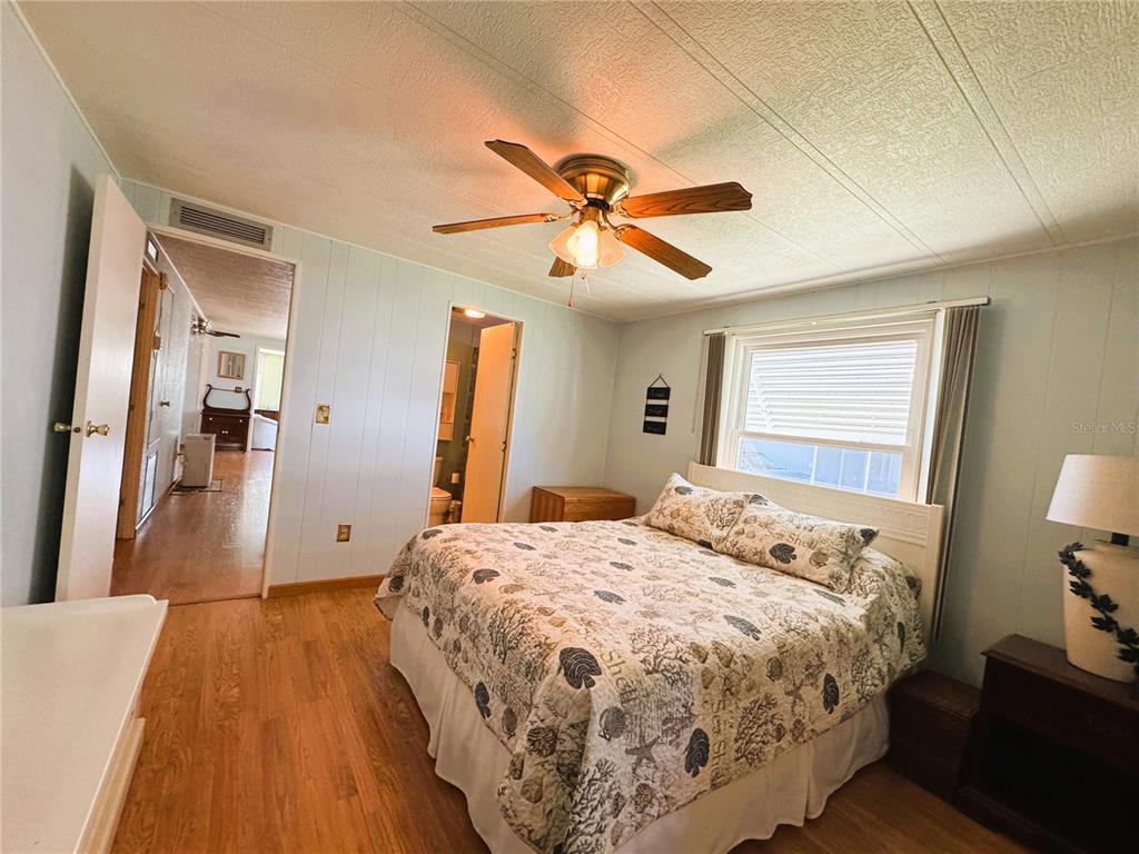 151 Hibiscus Way Leesburg, FL 34748 - Photo 21 of 30 a bedroom with a bed and wooden floor