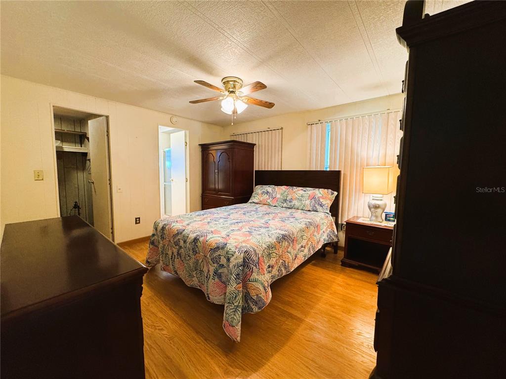 151 Hibiscus Way Leesburg, FL 34748 - Photo 22 of 30 a bedroom with a bed and a chandelier