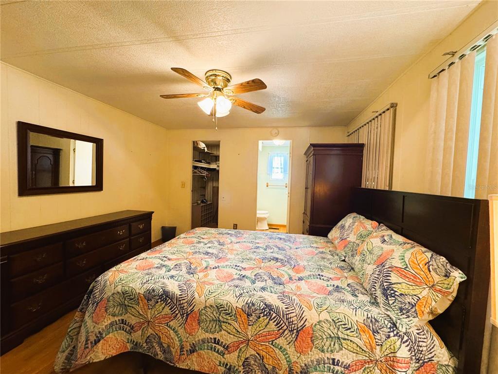 151 Hibiscus Way Leesburg, FL 34748 - Photo 23 of 30 a bedroom with a bed and a chandelier