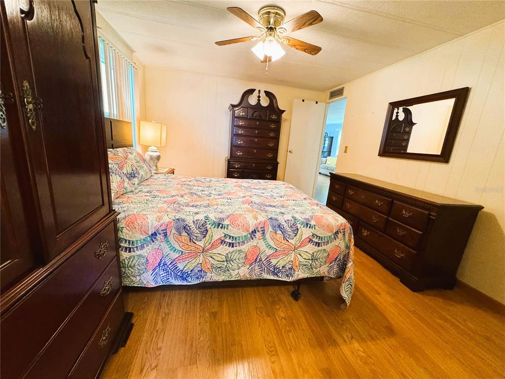 151 Hibiscus Way Leesburg, FL 34748 - Photo 27 of 30 a bedroom with a bed and wooden floor