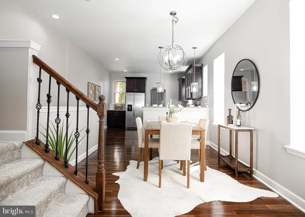 a view of a dining room with furniture a chandelier and wooden floor
