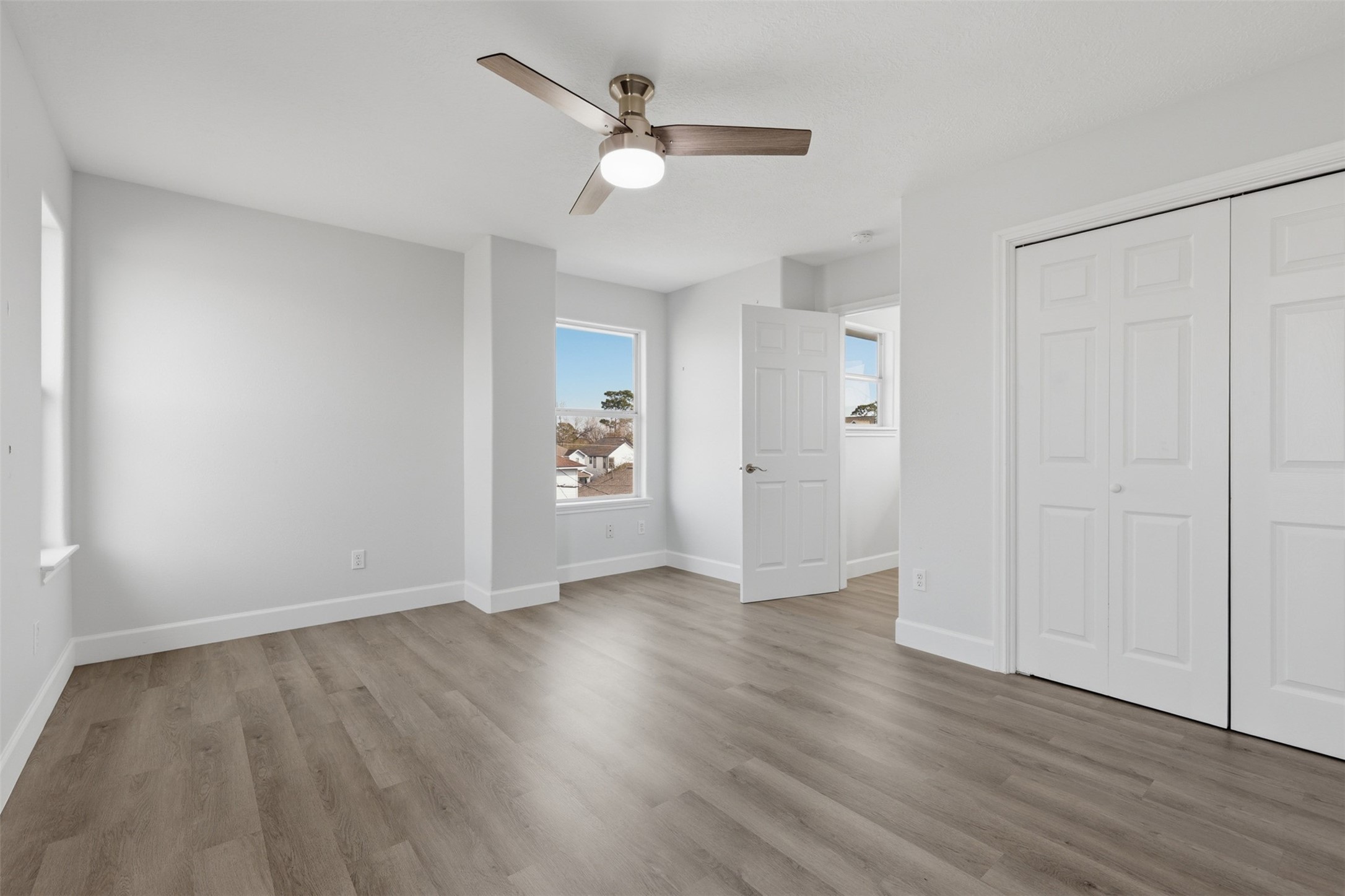 9026 McGallion Road Houston, TX 77022 - Photo 23 of 32 an empty room with wooden floor ceiling fan and window