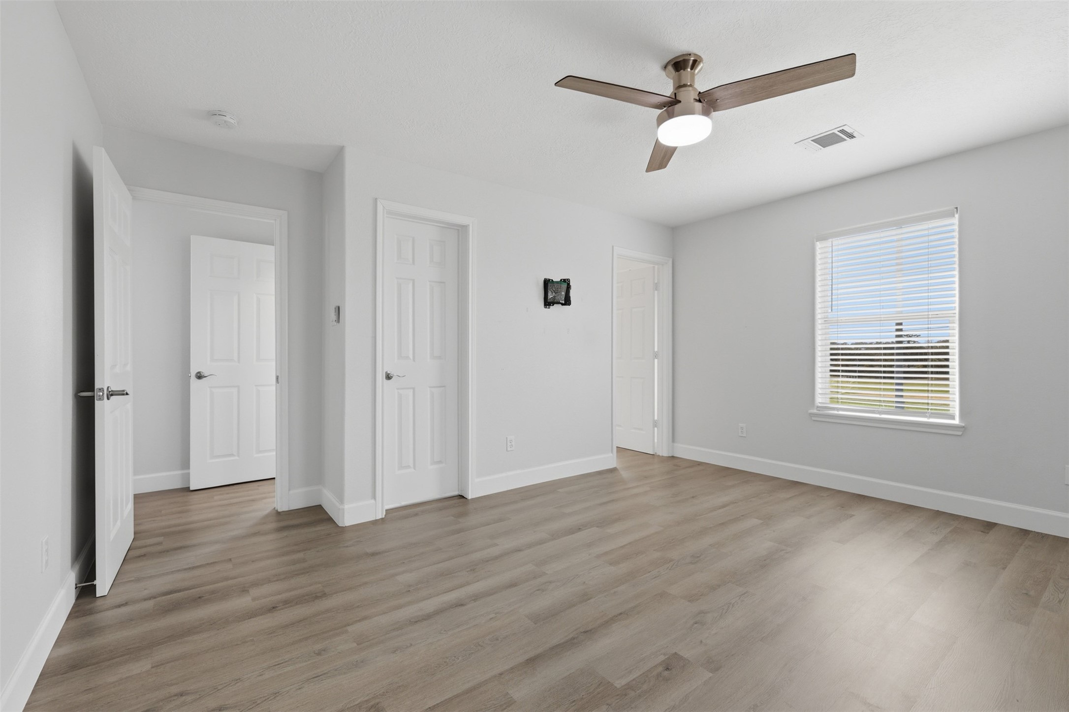 9026 McGallion Road Houston, TX 77022 - Photo 26 of 32 an empty room with wooden floor ceiling fan and windows