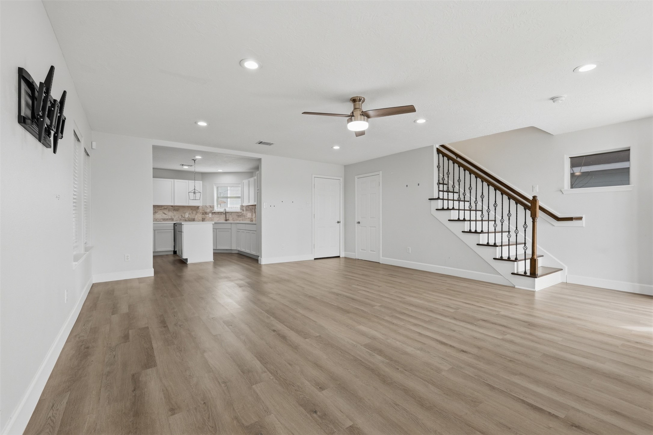 9026 McGallion Road Houston, TX 77022 - Photo 6 of 32 a view of an empty room with wooden floor and a ceiling fan