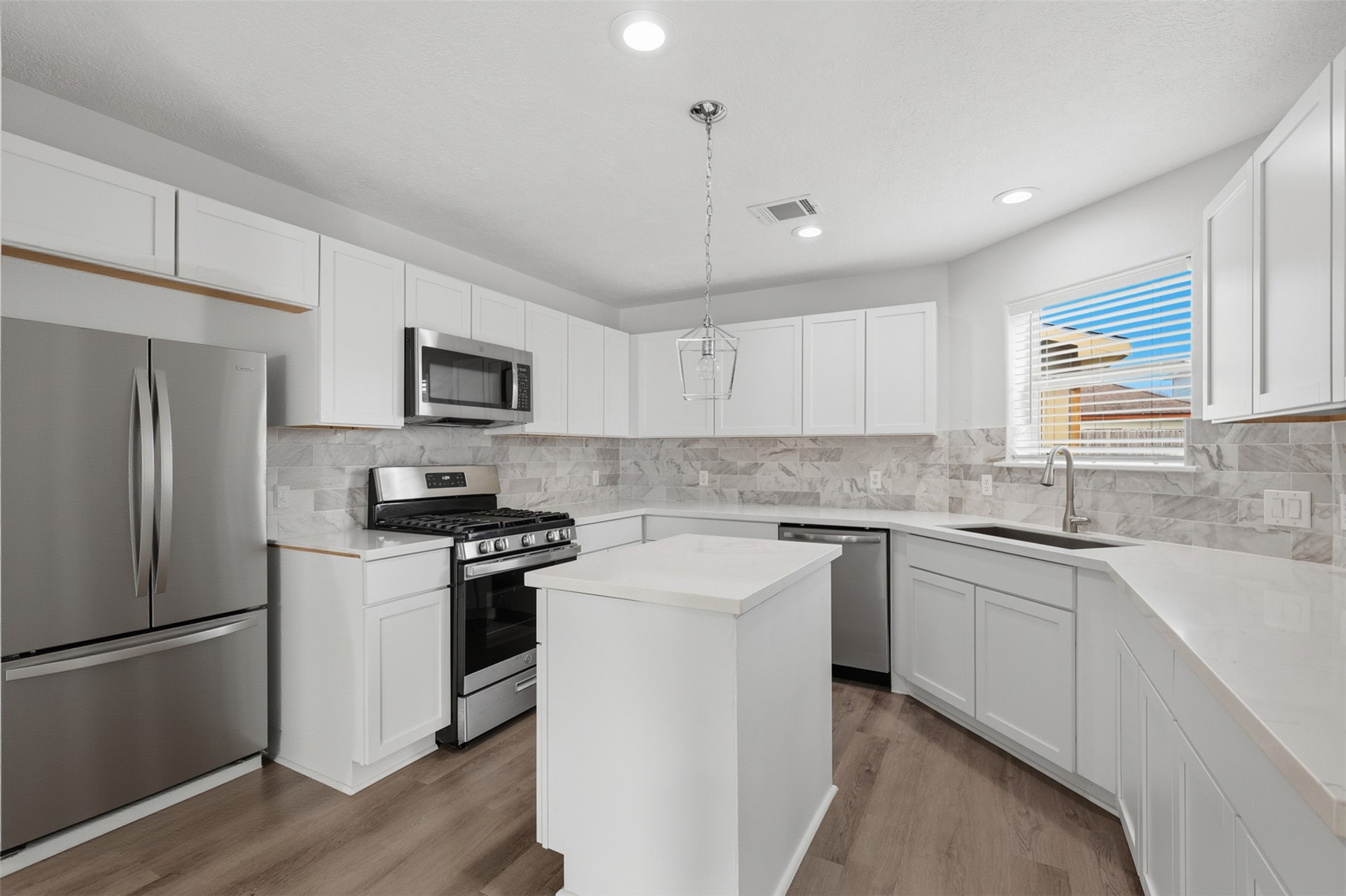 9026 McGallion Road Houston, TX 77022 - Photo 9 of 32 a kitchen with cabinets stainless steel appliances a sink and a window