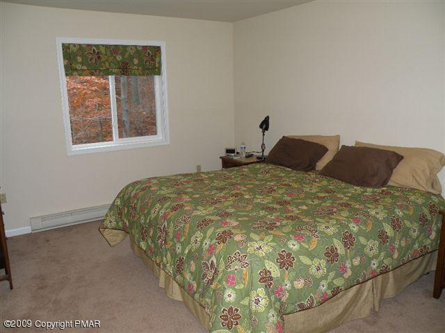 164 Elk Run Road Pocono Lake, PA 18347 - Photo 8 of 11 a bed sitting in a bedroom next to a window