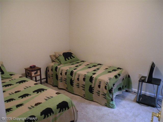 164 Elk Run Road Pocono Lake, PA 18347 - Photo 10 of 11 a bedroom with two bed and a chair
