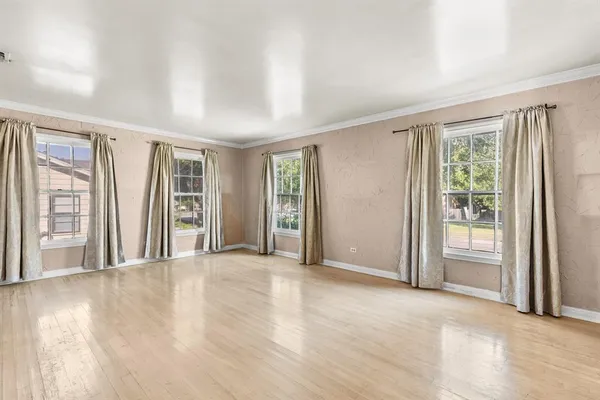 a view of an empty room with glass door and a window