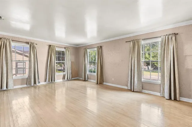 a view of an empty room with glass door and a window