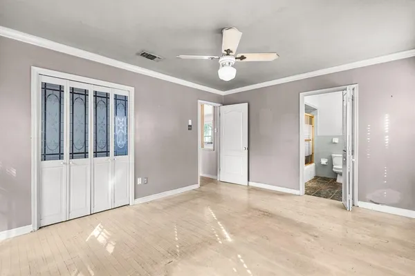 an empty room with fan and entrance