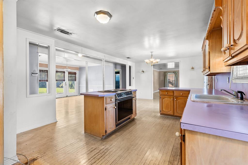 3120 Lyle Avenue Waco, TX 76708 - Photo 6 of 23 a kitchen with stainless steel appliances kitchen island wooden floors and center island