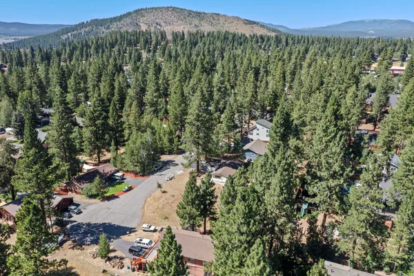 an aerial view of a house with a yard and mountain view in back