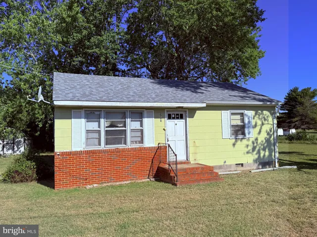 a view of house with backyard and sitting area