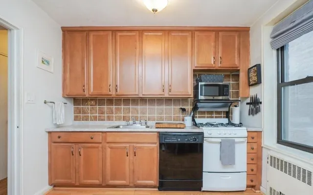 a kitchen with stainless steel appliances a stove microwave and cabinets