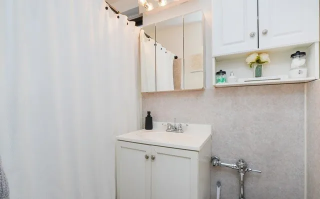 a bathroom with a sink a vanity and a shower