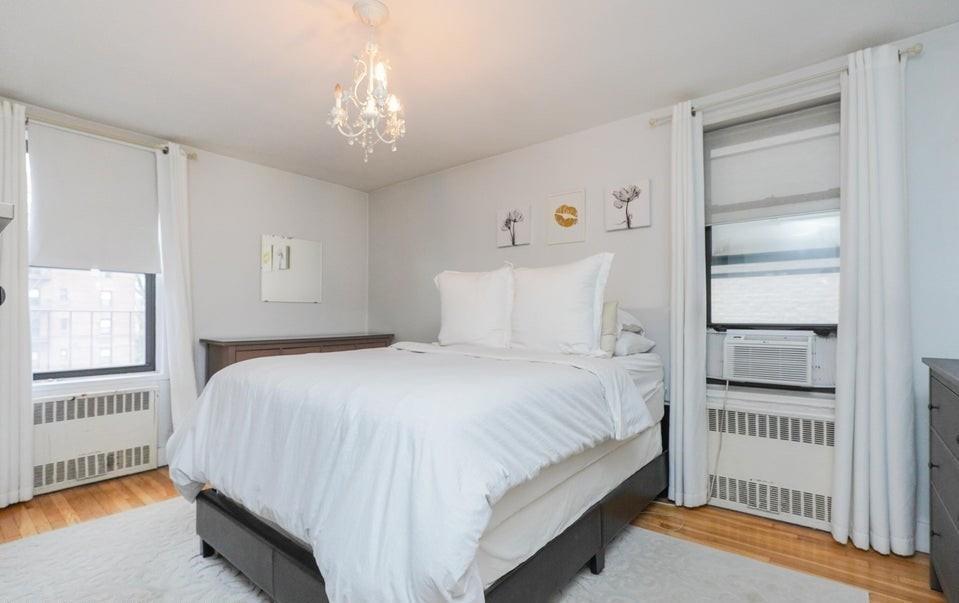 61 Oliver Street, Unit 2V Brooklyn, NY 11209 - Photo 16 of 23 a bedroom with a bed and a chandelier