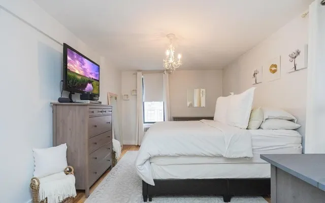 a bedroom with a bed and a flat screen tv