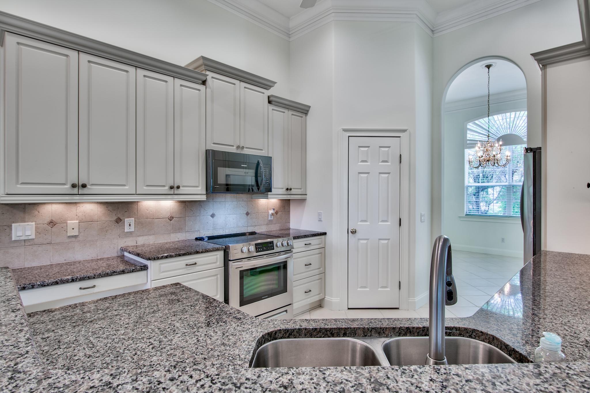359 Indigo Loop Miramar Beach, FL 32550 - Photo 12 of 47 a kitchen with stainless steel appliances granite countertop a sink a stove and a refrigerator with wooden floor