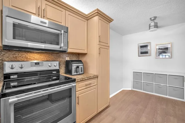 a kitchen with granite countertop a stove microwave and sink