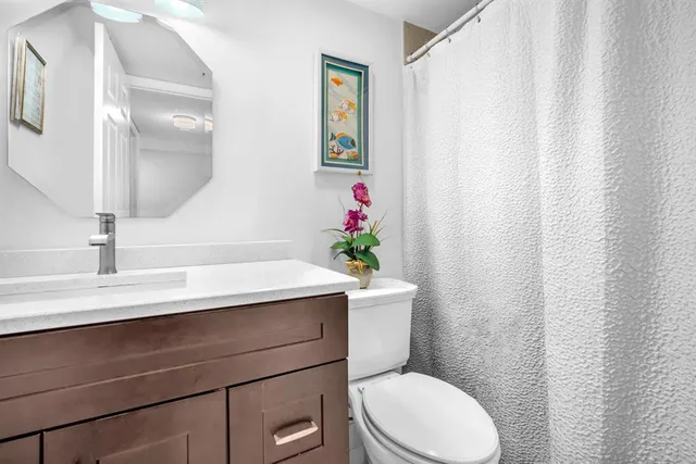 a bathroom with a sink a toilet and mirror