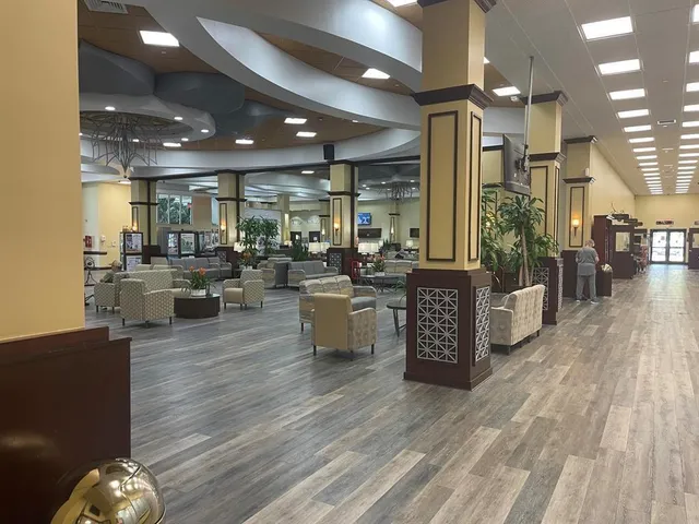 a view of a swimming pool with a patio and palm trees